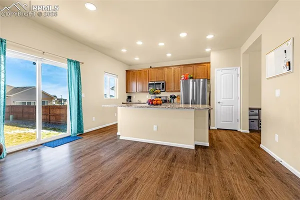 a kitchen with stainless steel appliances a refrigerator and wooden floor