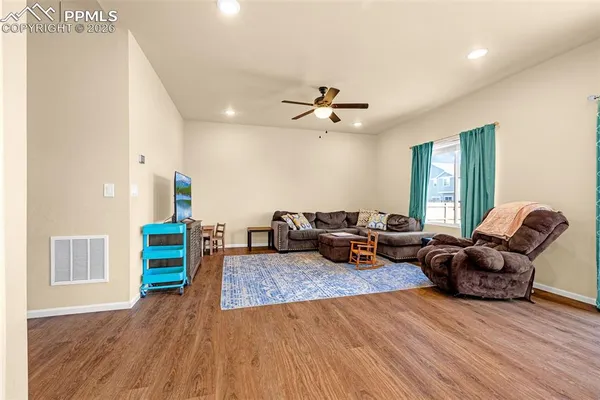 a living room with furniture and a wooden floor