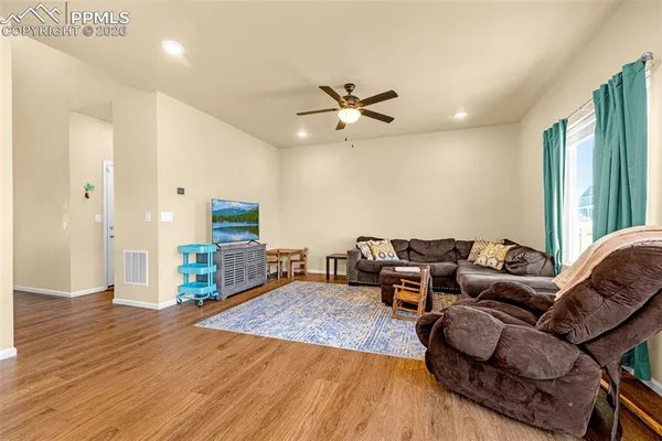 a living room with furniture and a wooden floor
