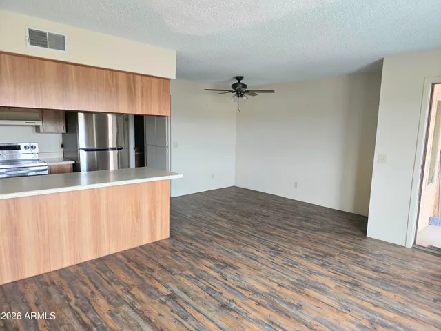 a kitchen with stainless steel appliances a wooden floor and window