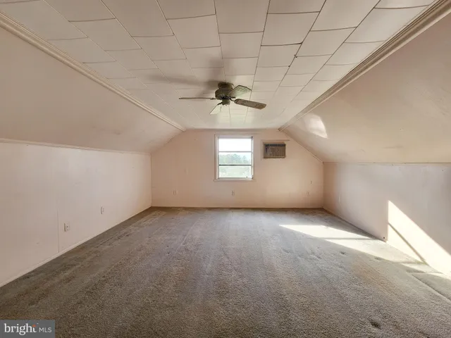 an empty room with a window and a ceiling fan