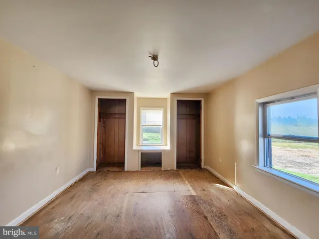 an empty room with windows and closet