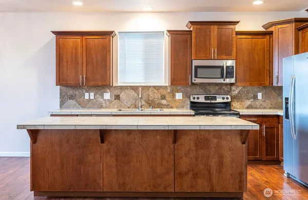 a kitchen with stainless steel appliances granite countertop a sink stove and microwave