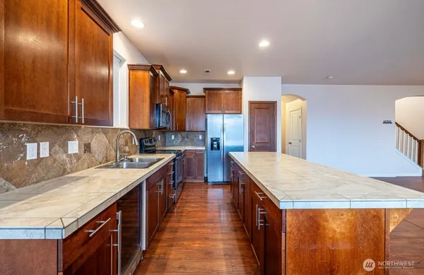 a kitchen with stainless steel appliances granite countertop sink stove and refrigerator
