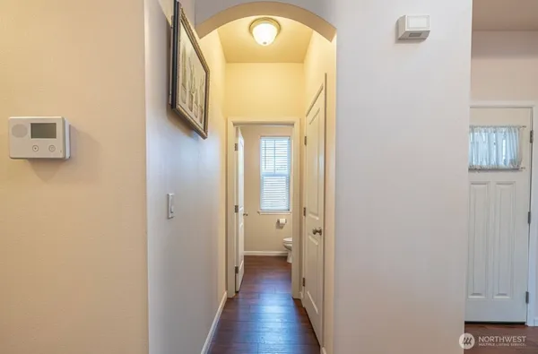 a view of a hallway with wooden floor and a mirror