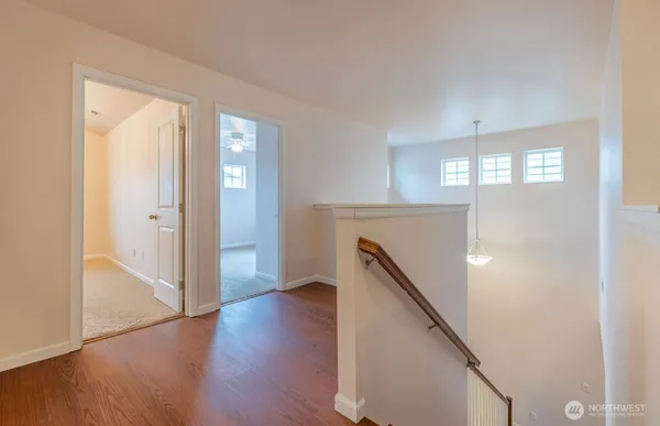 a view of a hallway with entryway wooden floor and stairs