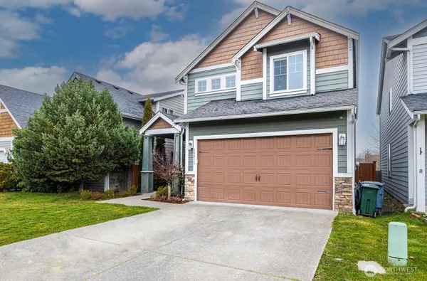 a front view of a house with a yard and garage