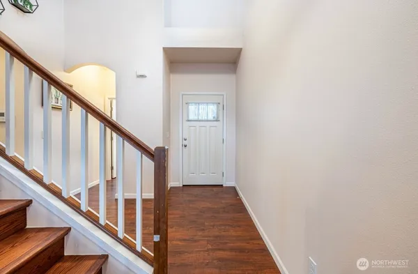 a view of a hallway with wooden floor and stairs