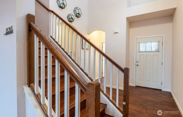 a view of staircase with lots of frames on wall and wooden floor