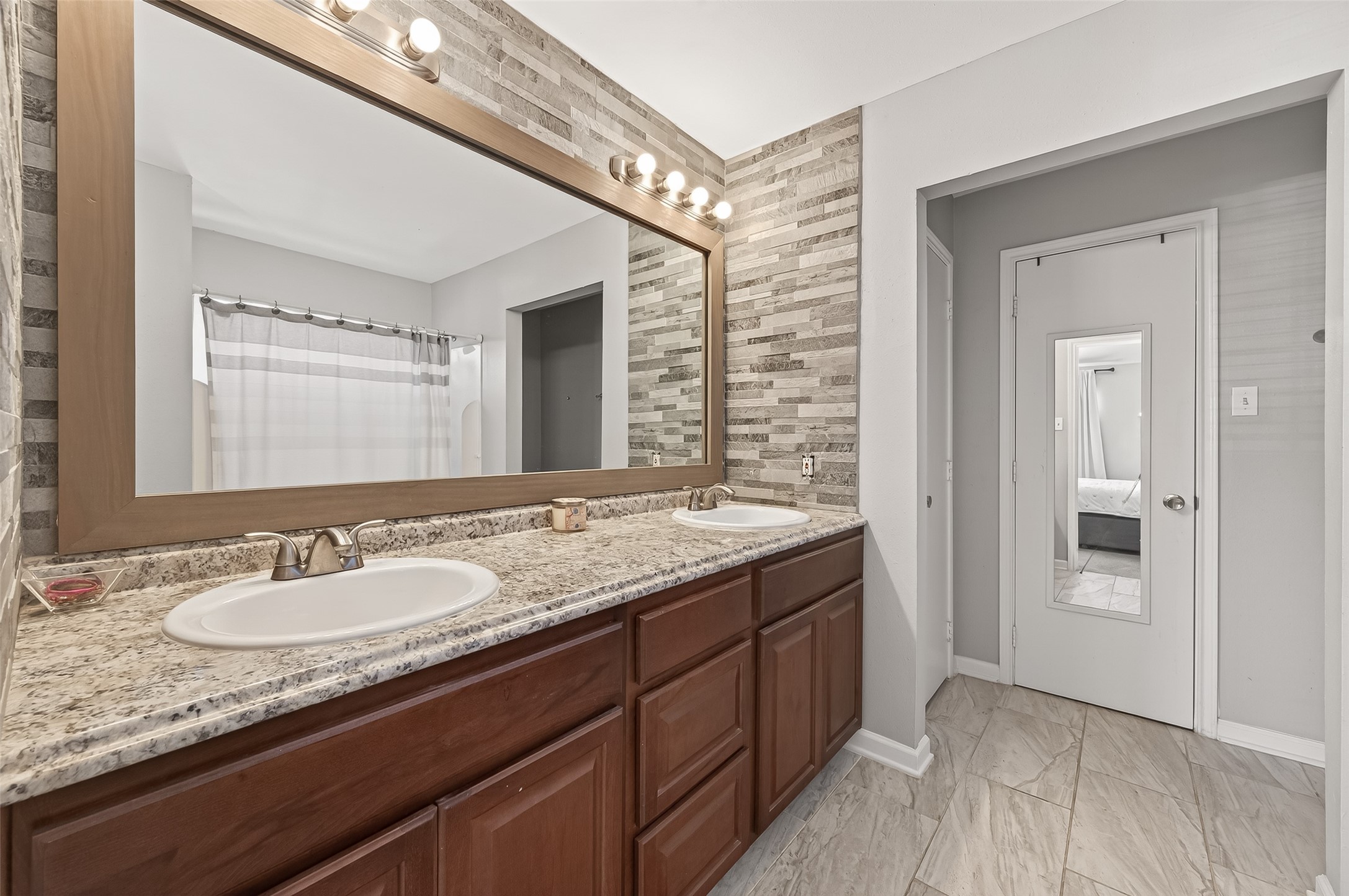 2202 Falling Oaks Road Houston, TX 77038 - Photo 28 of 47 a bathroom with a granite countertop sink and a mirror
