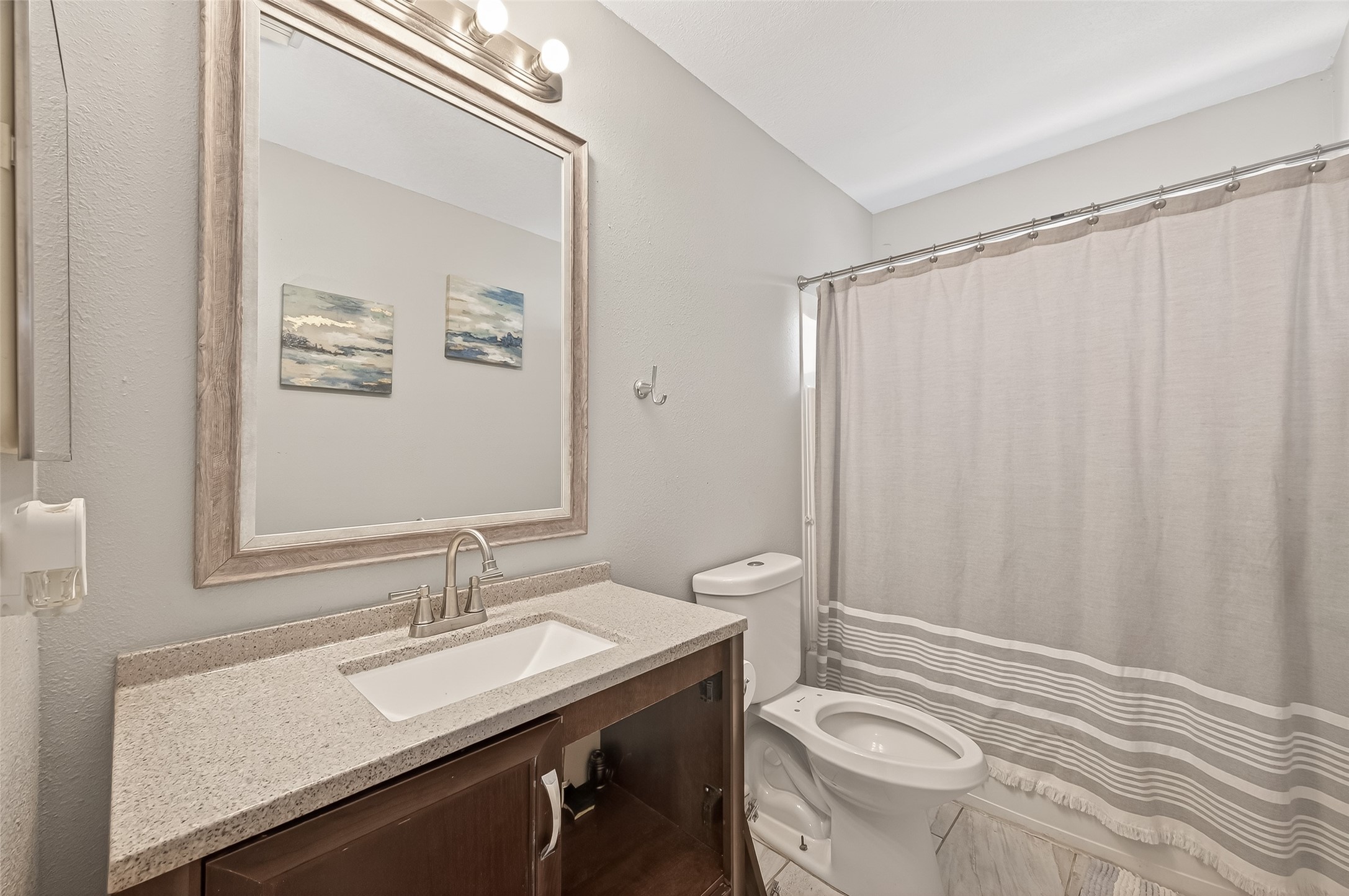 2202 Falling Oaks Road Houston, TX 77038 - Photo 37 of 47 a bathroom with a sink a toilet a mirror and shower curtain