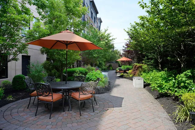 a patio with a table and chairs and potted plants