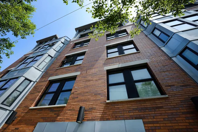 a view of a brick house with a yard and garage