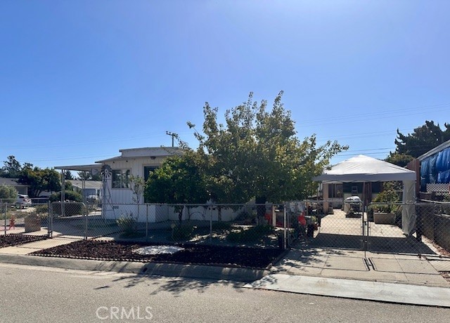 1180 Starlite Drive Nipomo, CA 93444 - Photo 3 of 35 a view of a patio with table and chairs under an umbrella with large trees