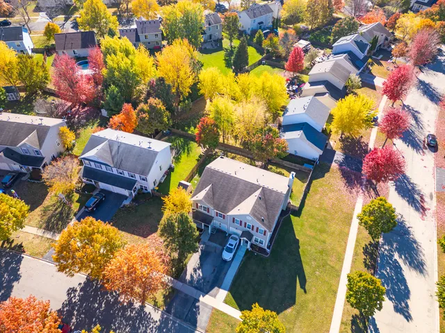 a aerial view of a house with swimming pool and large trees