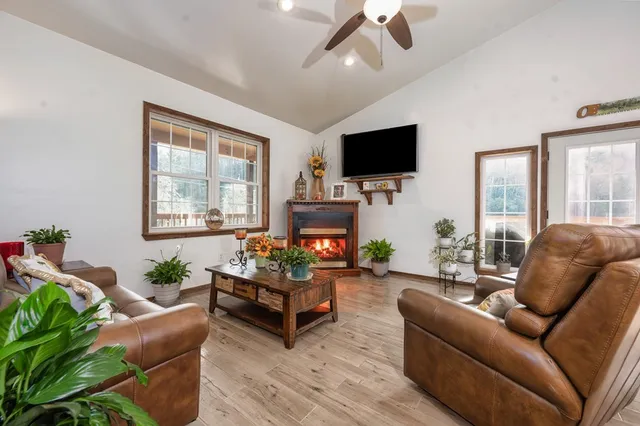 a living room with furniture a flat screen tv and a large window