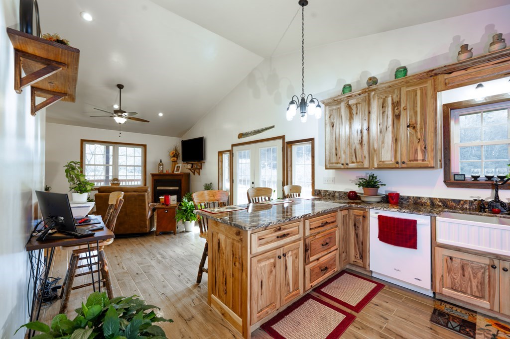 3234 Winding Stairs Road Topton, NC 28781 - Photo 9 of 32 a open kitchen with stainless steel appliances granite countertop a stove top oven a sink dishwasher a dining table and chairs with wooden floor