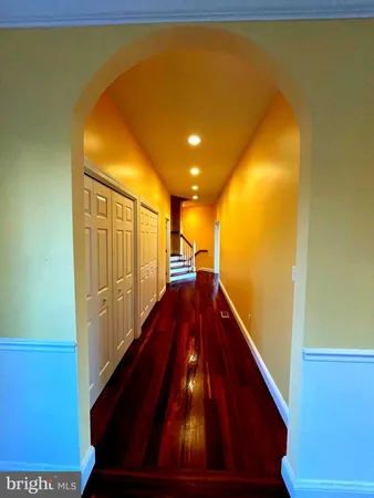 a view of a hallway with wooden floor and staircase