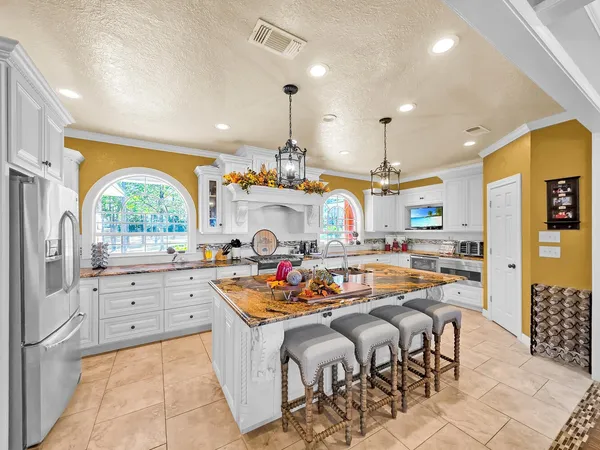 a living room with stainless steel appliances granite countertop a sink and a refrigerator
