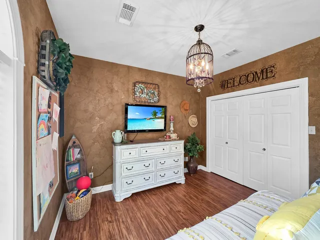 a view of a bedroom with wooden floor