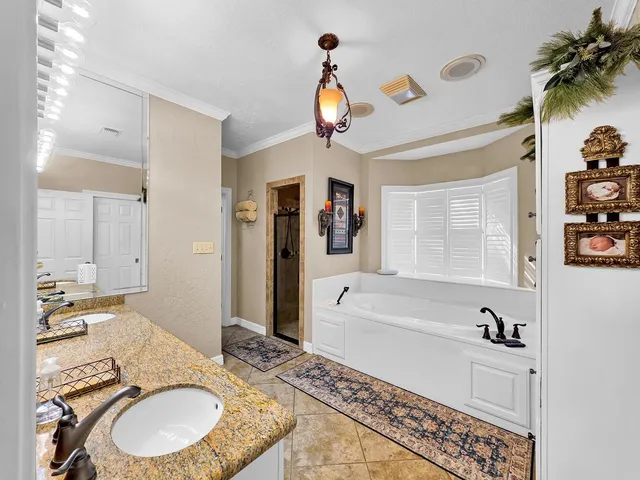 a bathroom with a granite countertop sink a mirror a vanity and bathtub