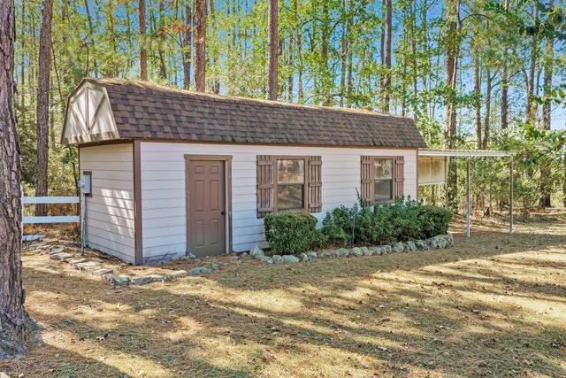 a view of a house with a yard and large tree