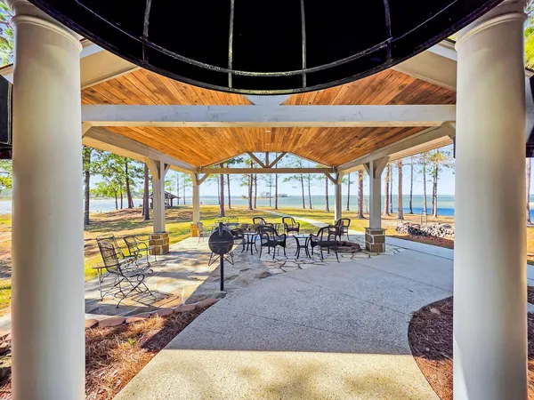 a view of a swimming pool with a chairs and table in the patio