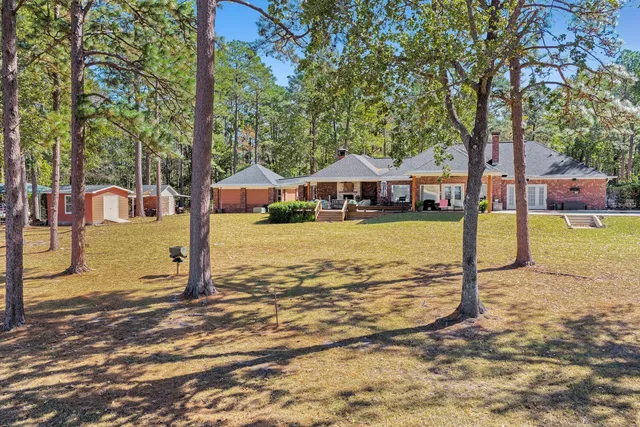a view of a house with swimming pool next to a yard