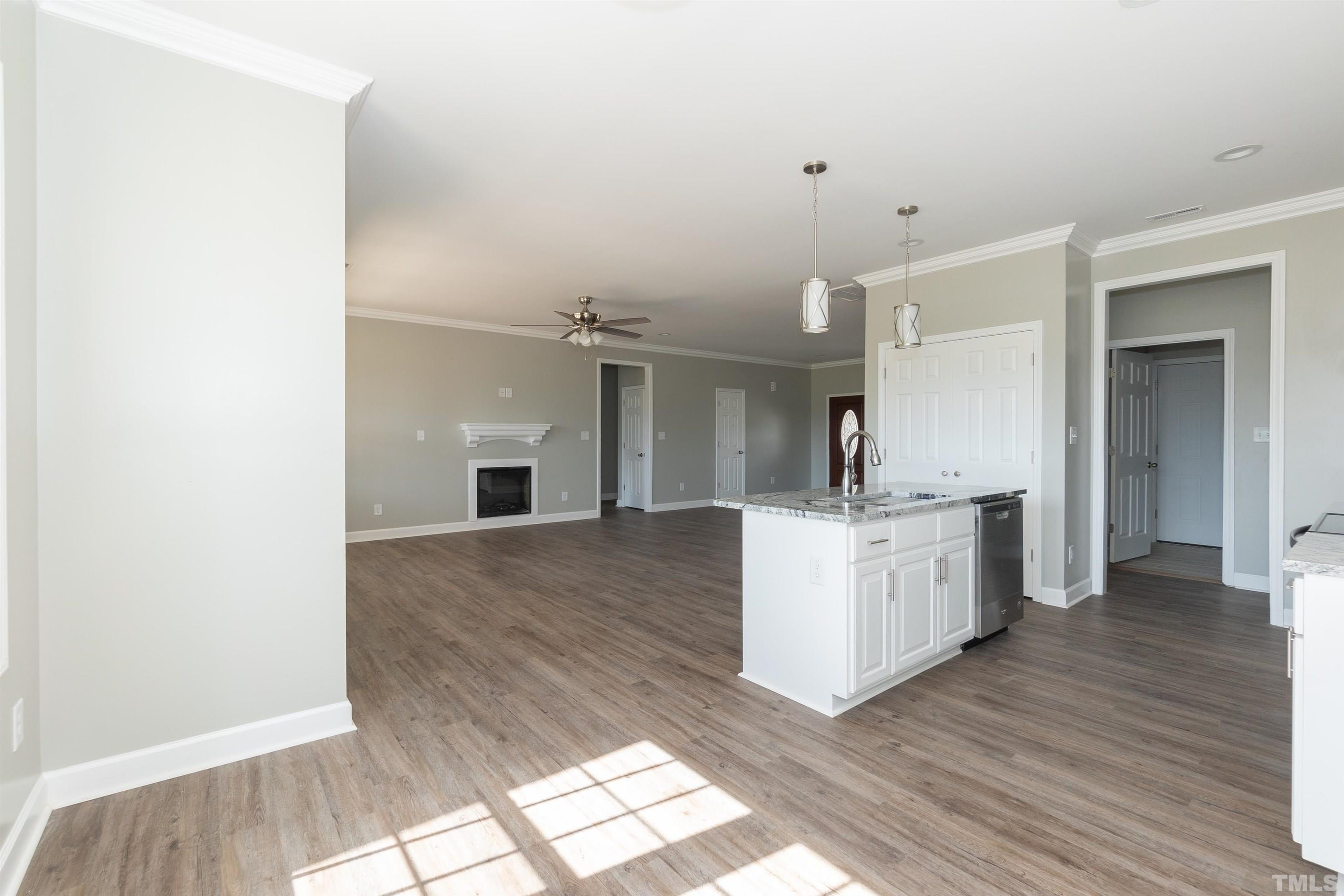 7149 Hill Road Spring Hope, NC 27882 - Photo 12 of 21 a room with kitchen island a sink wooden floor and a view of living room