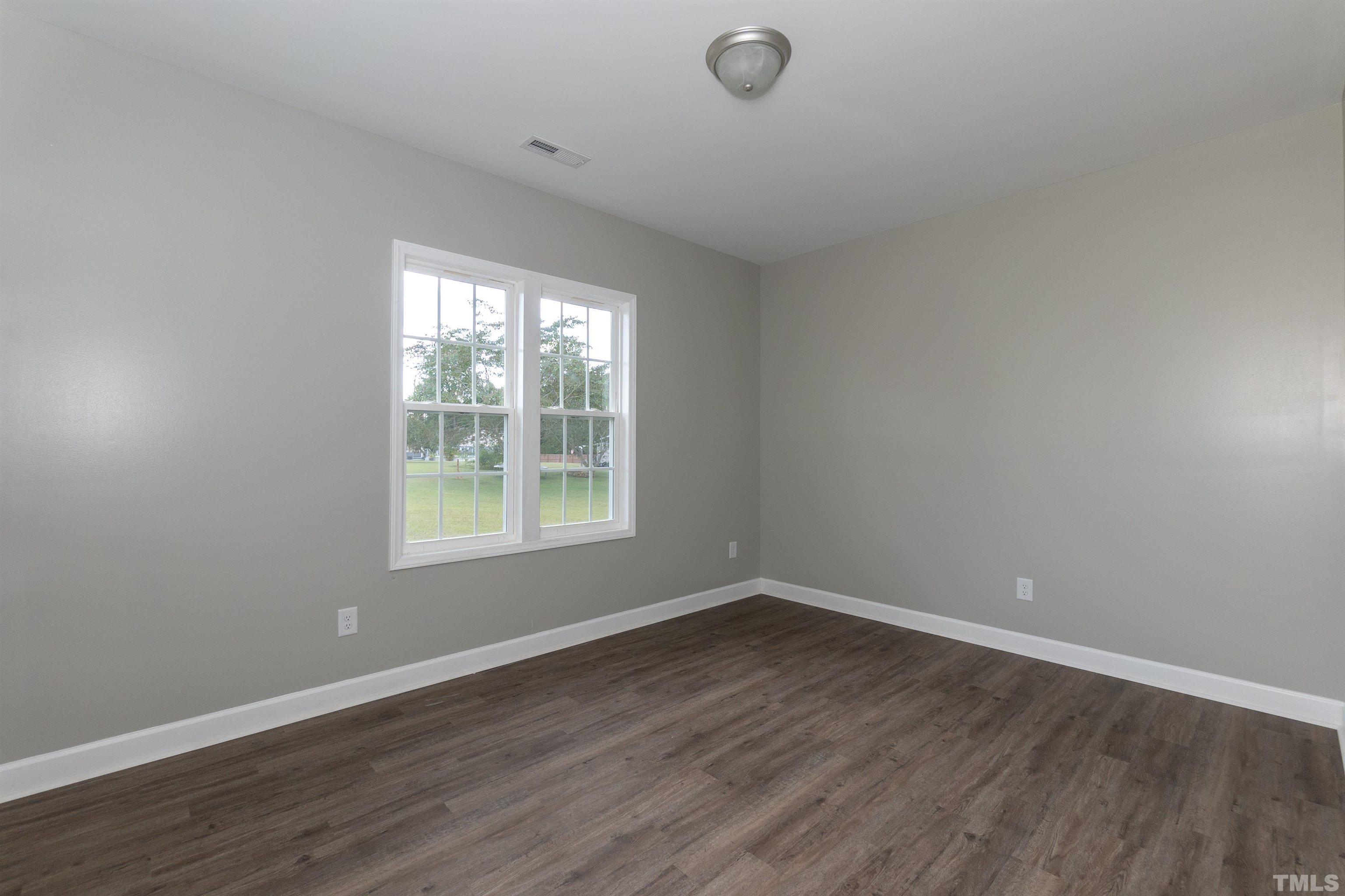 7149 Hill Road Spring Hope, NC 27882 - Photo 7 of 21 wooden floor in an empty room with a window