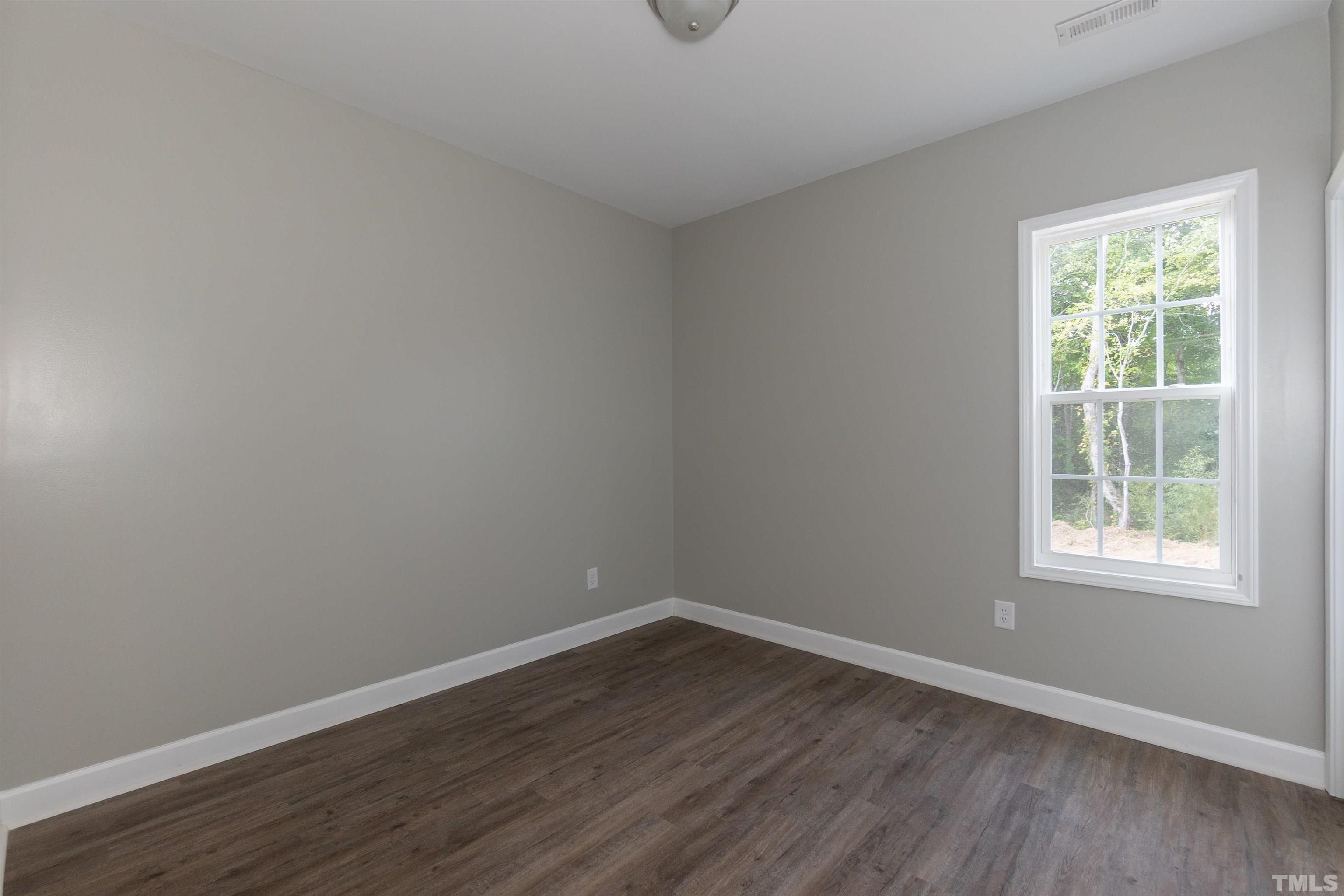 7149 Hill Road Spring Hope, NC 27882 - Photo 8 of 21 a view of an empty room with wooden floor and a window