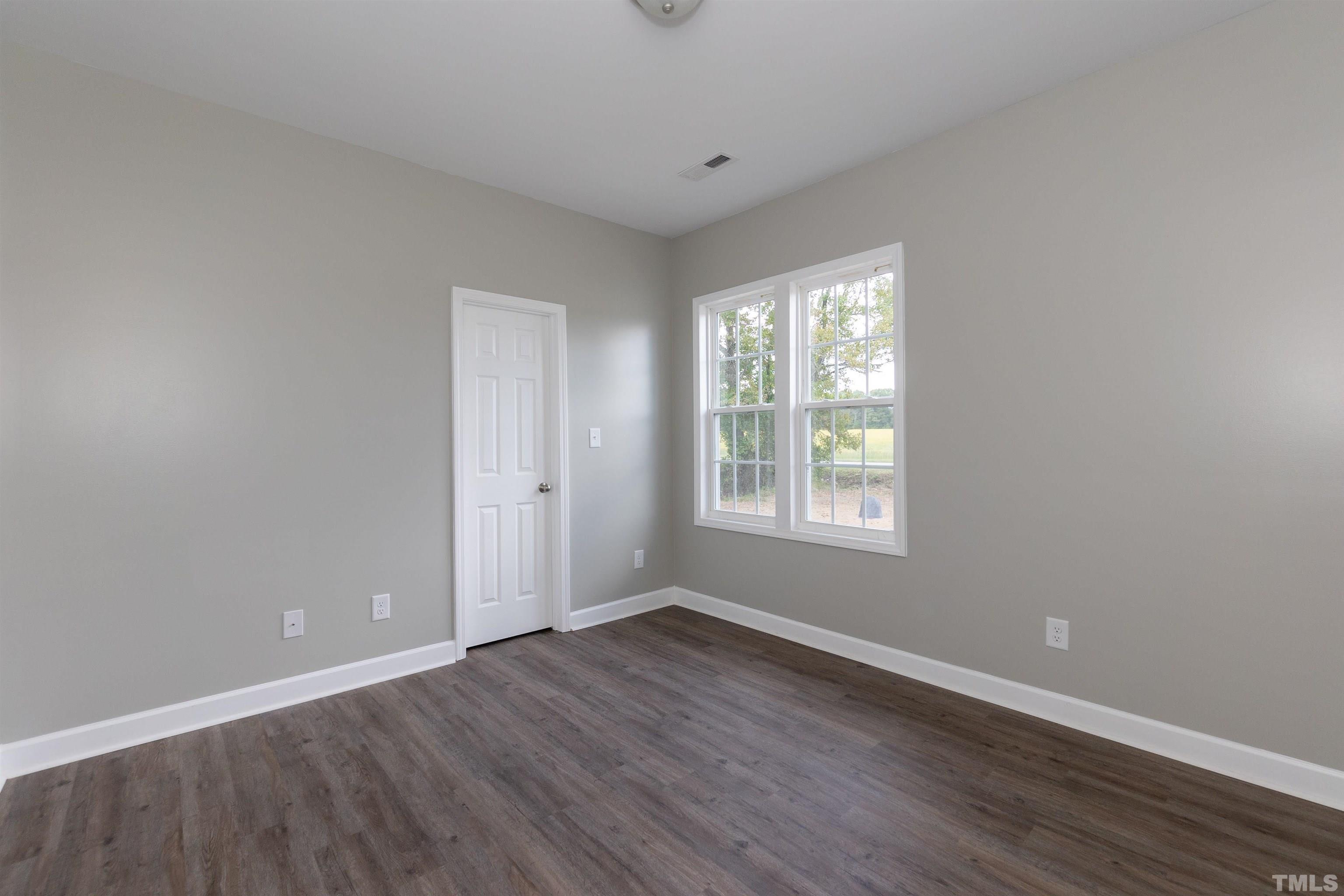 7149 Hill Road Spring Hope, NC 27882 - Photo 9 of 21 a view of an empty room with wooden floor and a window