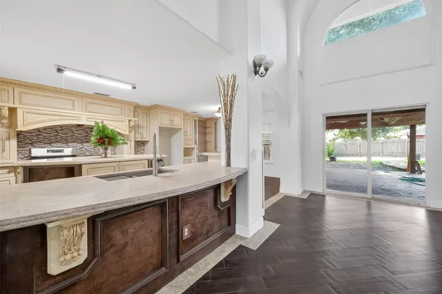 a kitchen with stainless steel appliances granite countertop a sink a stove and a wooden floors