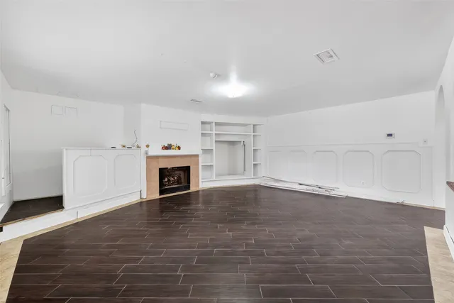 a view of a livingroom with a fireplace a fireplace and windows