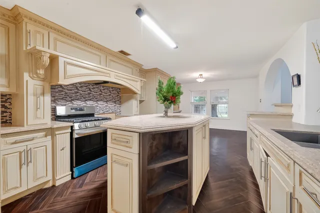 a kitchen with stainless steel appliances granite countertop a sink and dishwasher a stove with wooden floor