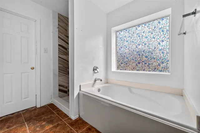 a bathroom with a bathtub and a shower