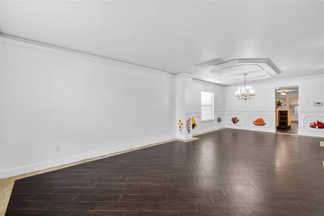 an empty room with wooden floor and white walls