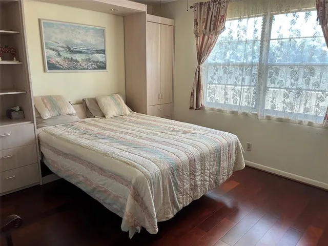 a bedroom with a bed and a painting on the wall