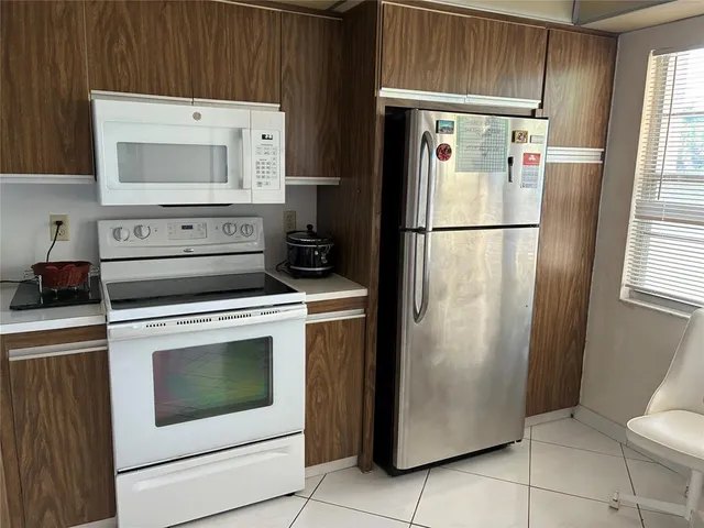 a white refrigerator freezer and a stove sitting inside of a kitchen