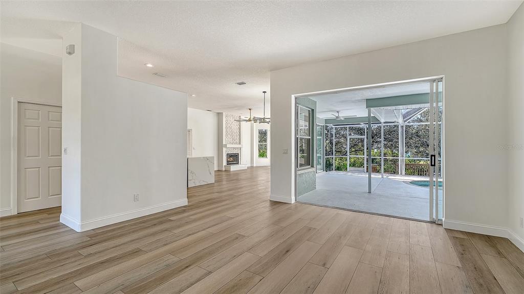 5402 Caruso Road Bradenton, FL 34203 - Photo 18 of 84 a view of empty room with wooden floor and fan