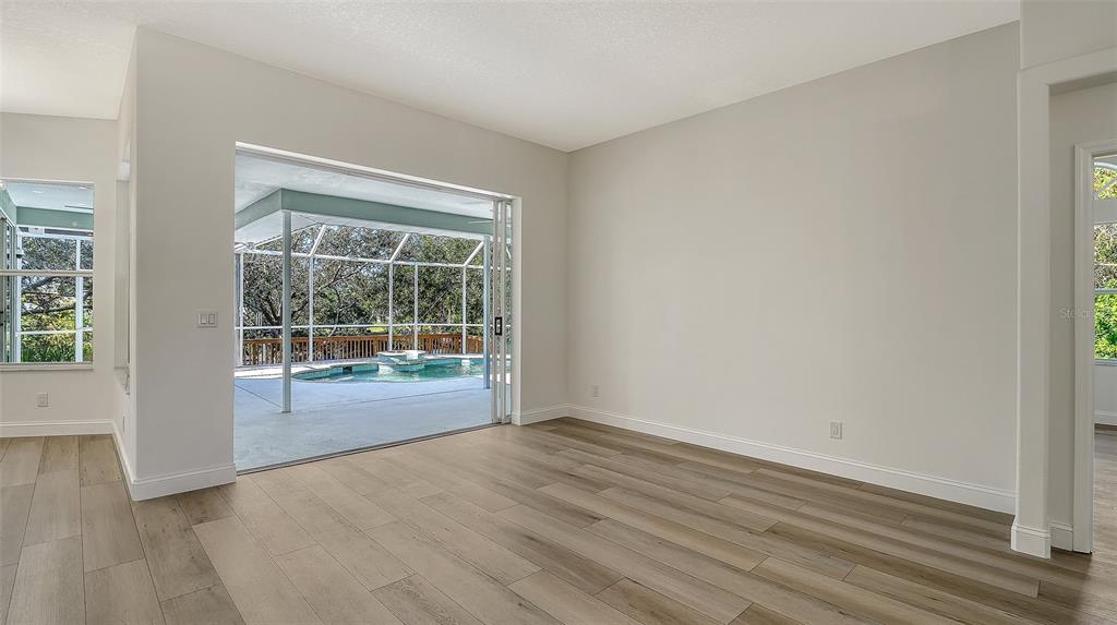 5402 Caruso Road Bradenton, FL 34203 - Photo 19 of 84 a view of an empty room with wooden floor and a window