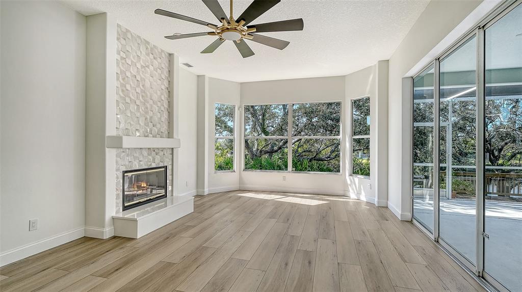 5402 Caruso Road Bradenton, FL 34203 - Photo 32 of 84 a view of livingroom with furniture a fireplace and wooden floor