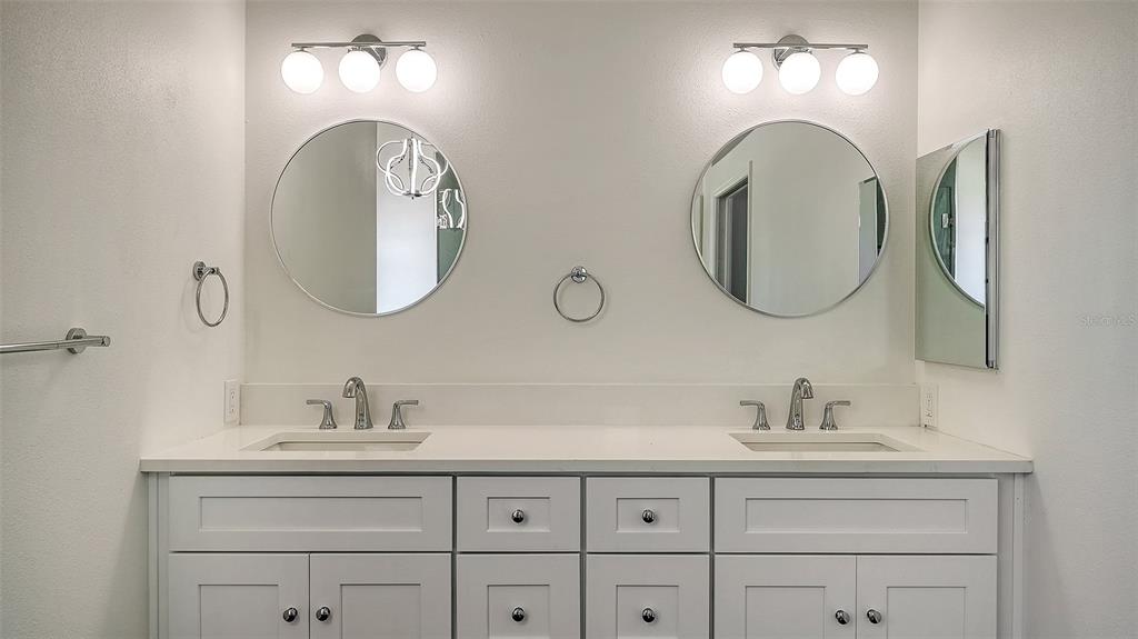 5402 Caruso Road Bradenton, FL 34203 - Photo 49 of 84 a bathroom with double vanity sinks and a mirror