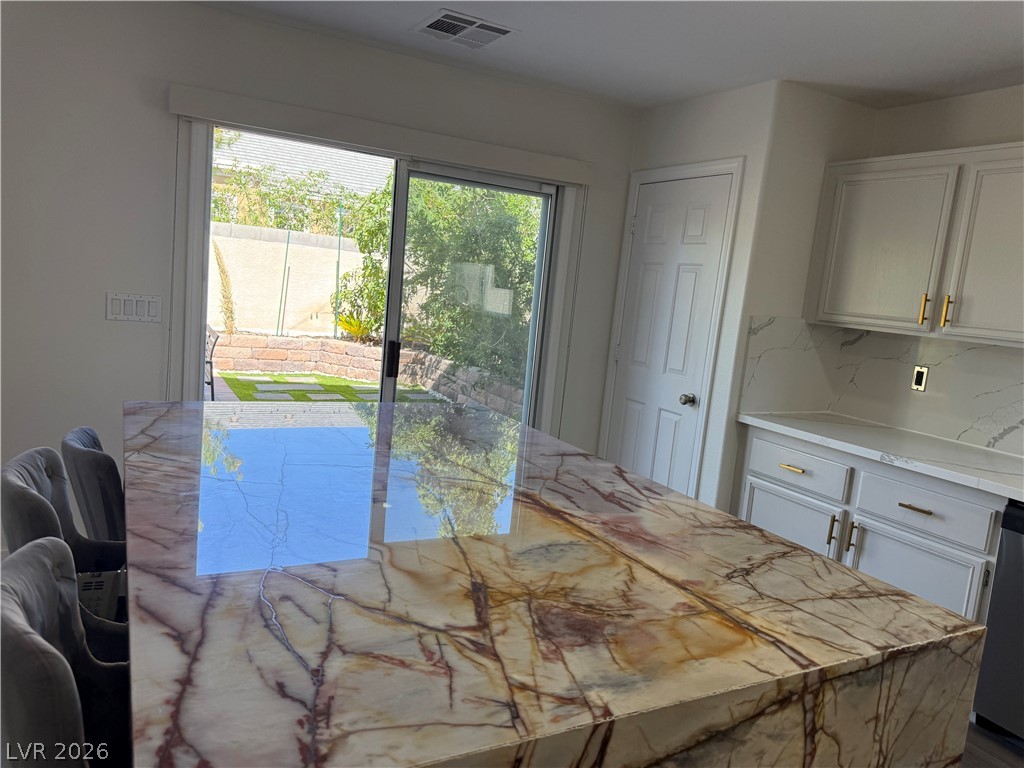 1141 Cathedral Ridge Street Henderson, NV 89052 - Photo 23 of 77 This modern kitchen features a generously sized island with elegant countertops, perfect for culinary endeavors.