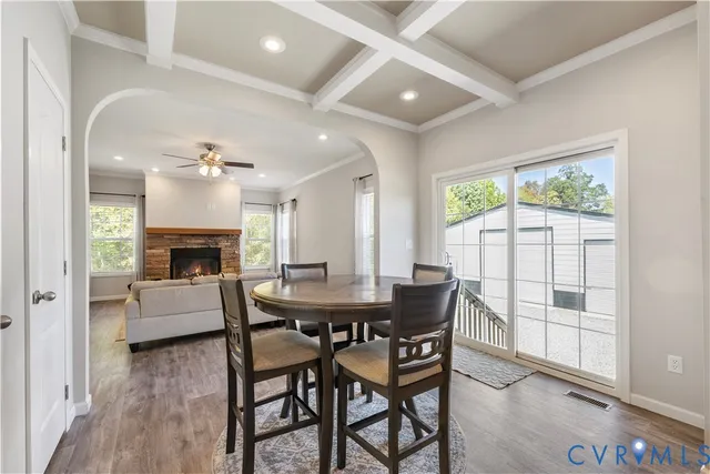 a dining room with furniture a fireplace and wooden floor