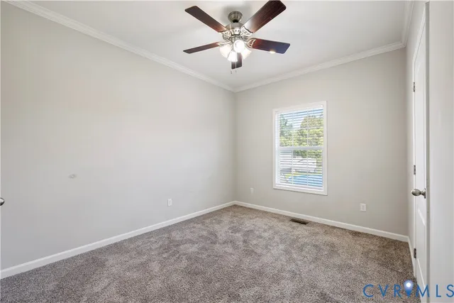 a view of an empty room and chandelier fan