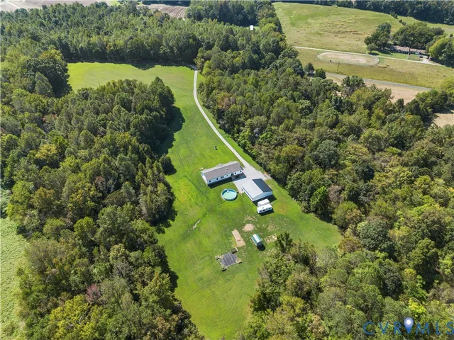 an aerial view of a residential houses with yard