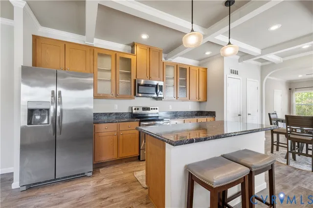 a kitchen with stainless steel appliances granite countertop a refrigerator a sink and a stove