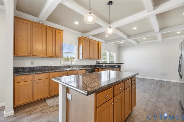 a kitchen with stainless steel appliances granite countertop a sink a stove and a wooden cabinets