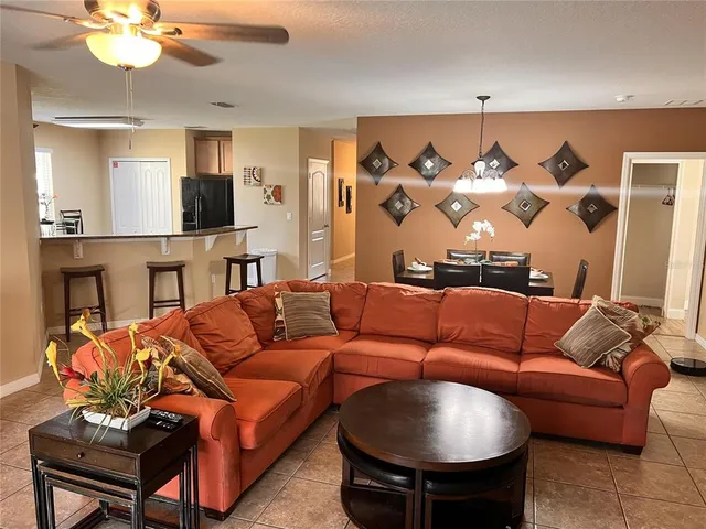 a living room with furniture a chandelier and a flat screen tv